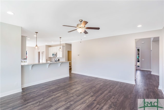 unfurnished living room with dark hardwood / wood-style floors and ceiling fan