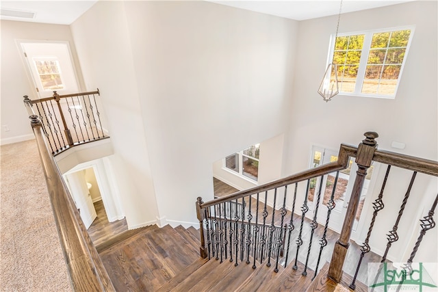 stairs featuring a chandelier and hardwood / wood-style flooring