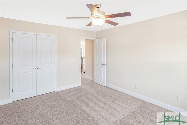 unfurnished bedroom featuring ceiling fan, light colored carpet, and a closet