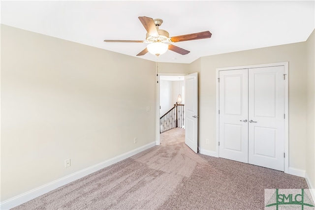 unfurnished bedroom with ceiling fan, light carpet, and a closet