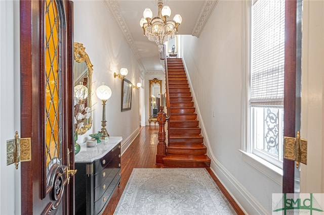 stairway with crown molding, hardwood / wood-style floors, and plenty of natural light