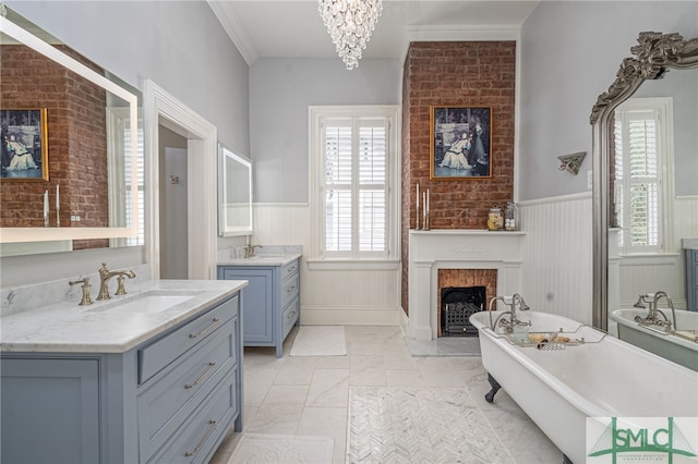 bathroom with vanity, a fireplace, a bathtub, and a healthy amount of sunlight