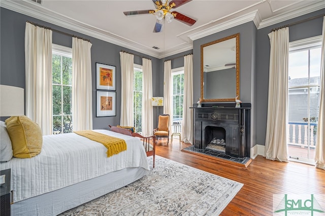 bedroom with ceiling fan, access to exterior, hardwood / wood-style flooring, and ornamental molding