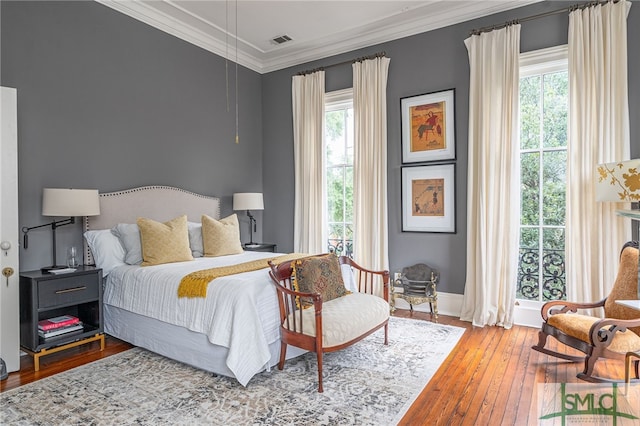 bedroom with hardwood / wood-style floors and crown molding