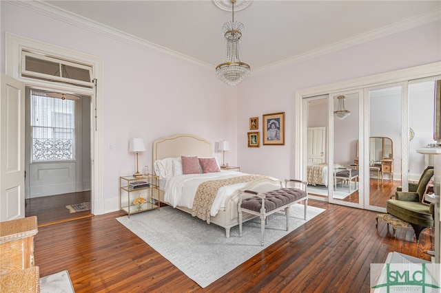 bedroom with a notable chandelier, dark wood-type flooring, and crown molding