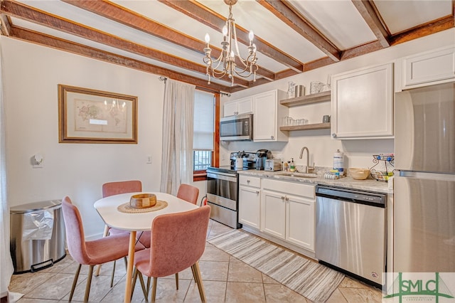 kitchen featuring white cabinetry, pendant lighting, stainless steel appliances, sink, and a chandelier