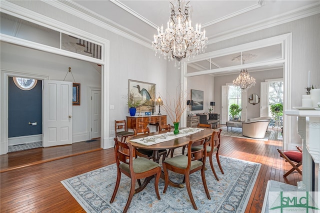 dining space featuring ornamental molding, an inviting chandelier, and hardwood / wood-style flooring