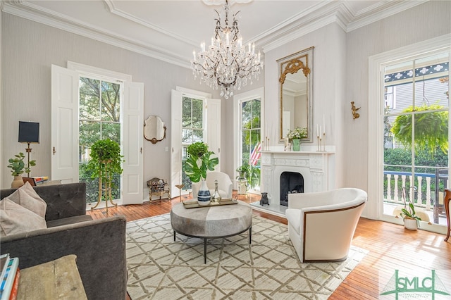 living room with a notable chandelier, a wealth of natural light, and light hardwood / wood-style floors