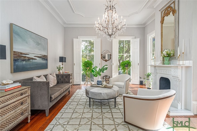 living room with an inviting chandelier, wood-type flooring, and crown molding