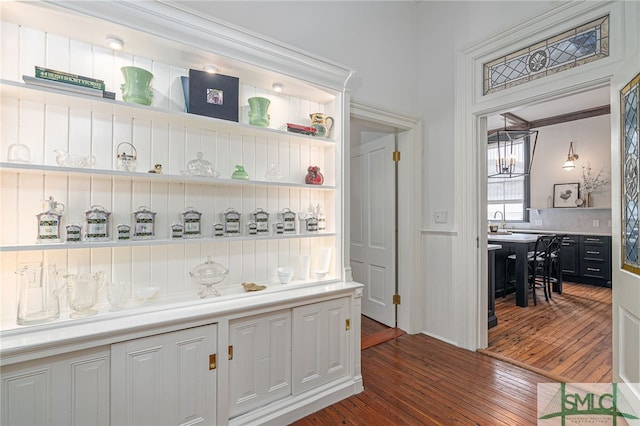 kitchen with ornamental molding, sink, and dark wood-type flooring