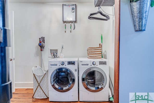 washroom with washer and clothes dryer, hardwood / wood-style floors, and water heater