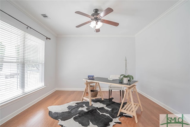 office space featuring light hardwood / wood-style floors, ceiling fan, a healthy amount of sunlight, and crown molding