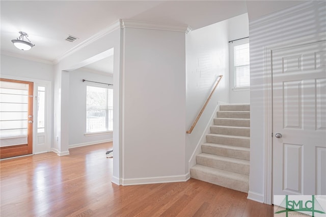 entrance foyer featuring light hardwood / wood-style flooring and crown molding