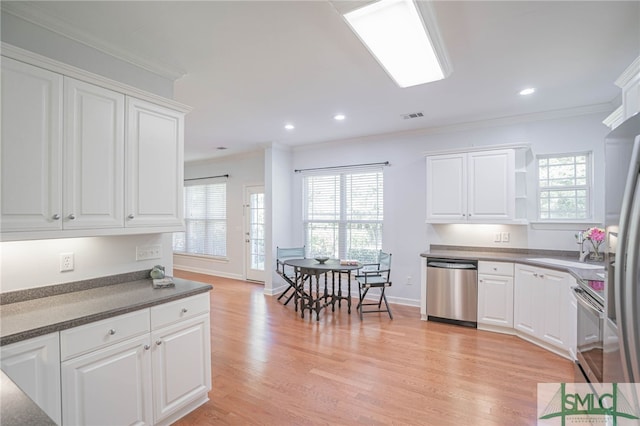 kitchen featuring stainless steel appliances, white cabinetry, and a wealth of natural light