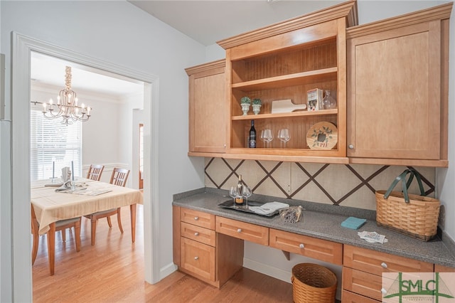 office space featuring an inviting chandelier, crown molding, and light hardwood / wood-style floors