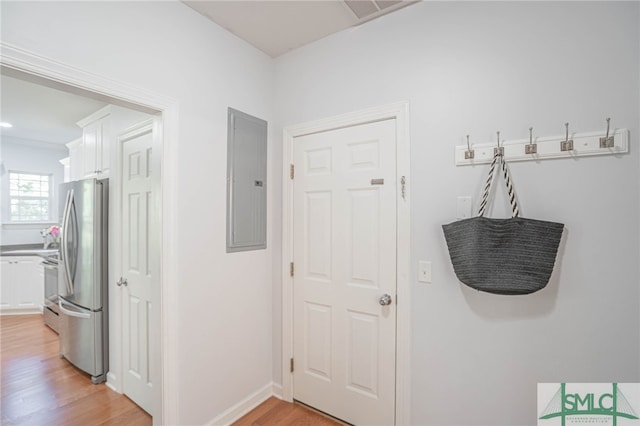 hallway with light hardwood / wood-style floors and electric panel