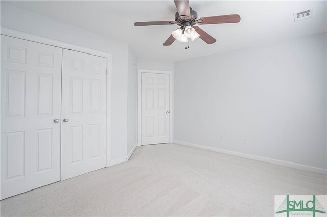 unfurnished bedroom with light carpet, ceiling fan, and a closet