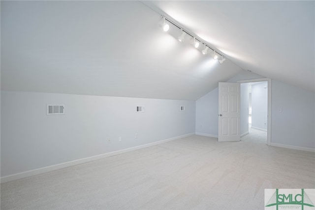 additional living space with vaulted ceiling and light colored carpet