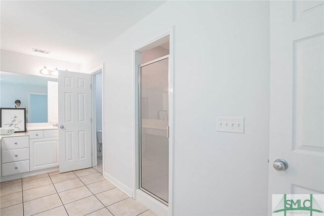 bathroom with vanity, tile patterned floors, and a shower with door