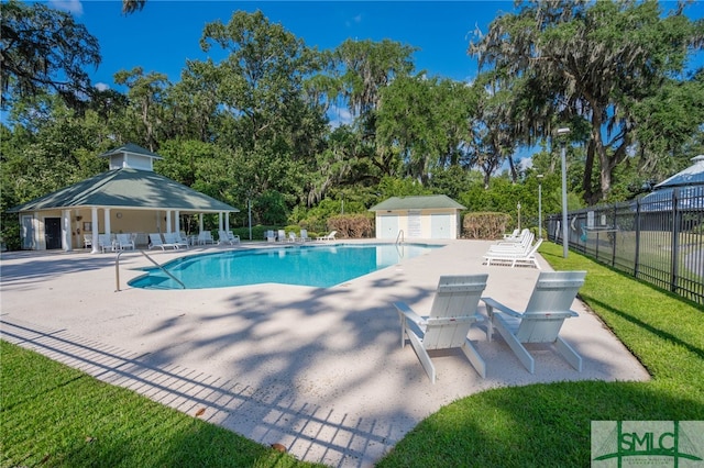 view of pool featuring a gazebo, a yard, a patio area, and an outbuilding