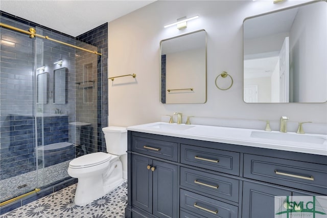 bathroom featuring toilet, vanity, tile patterned floors, and a shower with shower door