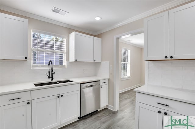 kitchen featuring dishwasher, backsplash, white cabinetry, and sink