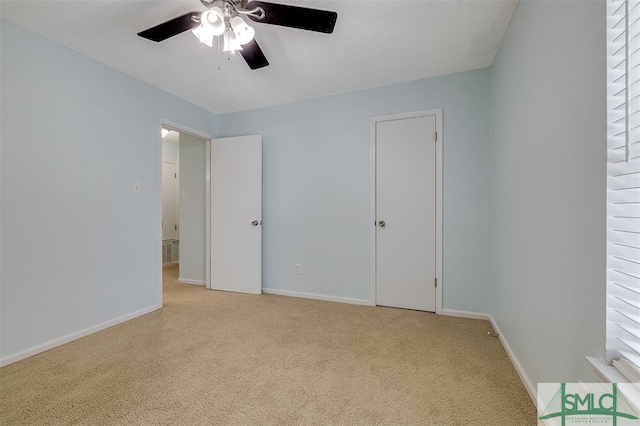 unfurnished bedroom with ceiling fan and light colored carpet