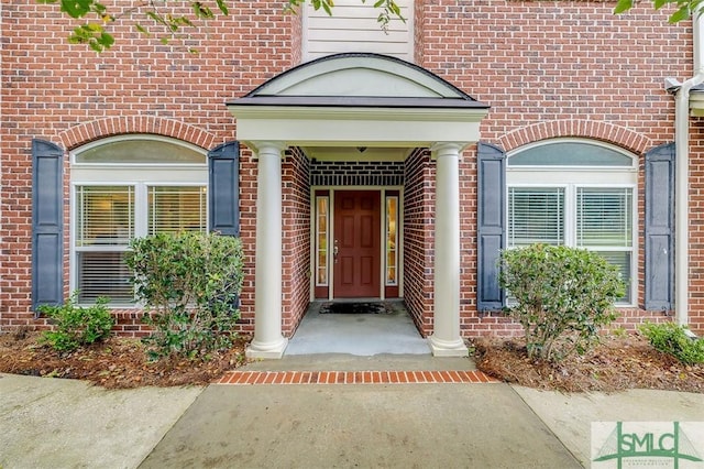 property entrance featuring brick siding