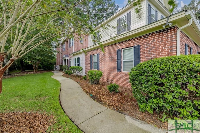 view of home's exterior with a yard and brick siding