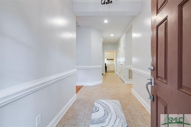 hall with light tile patterned floors, recessed lighting, visible vents, and baseboards