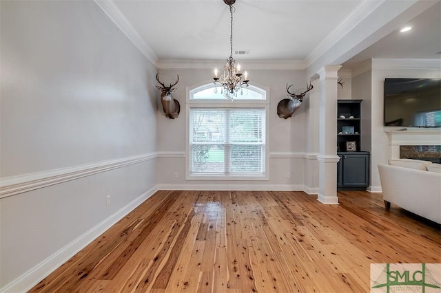 unfurnished dining area with decorative columns, visible vents, light wood-style flooring, crown molding, and a chandelier