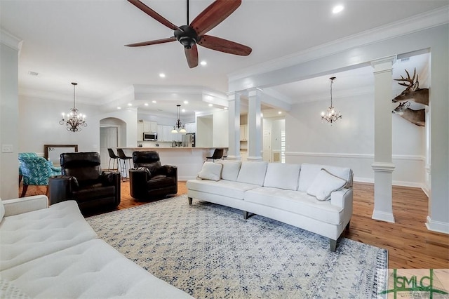 living room featuring decorative columns, ornamental molding, and hardwood / wood-style floors