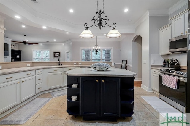 kitchen featuring stainless steel appliances, light countertops, a kitchen island, and hanging light fixtures