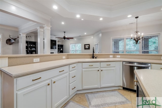 kitchen with light countertops, stainless steel dishwasher, open floor plan, white cabinets, and a sink