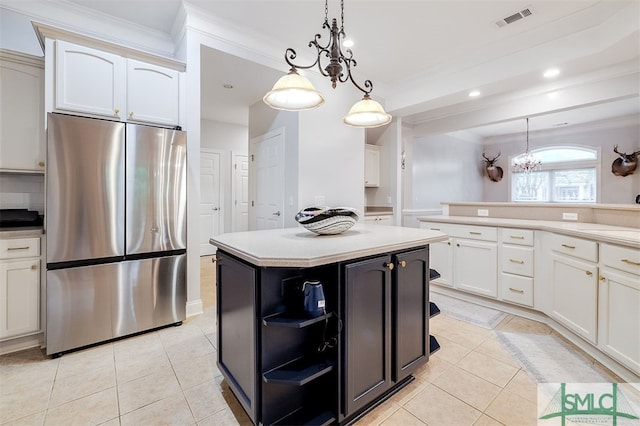 kitchen with freestanding refrigerator, white cabinets, light countertops, and visible vents