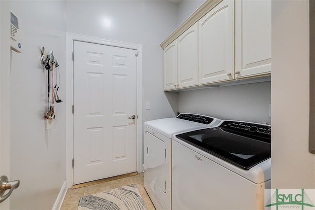 laundry room with cabinet space, light tile patterned floors, and washer and dryer