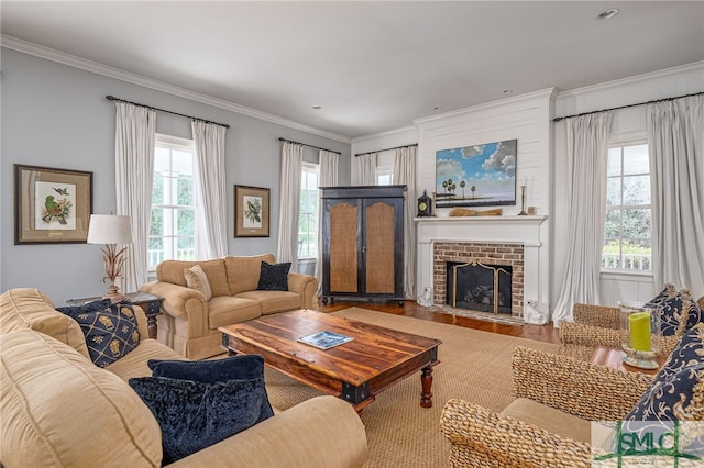 living room with wood-type flooring, a fireplace, and ornamental molding