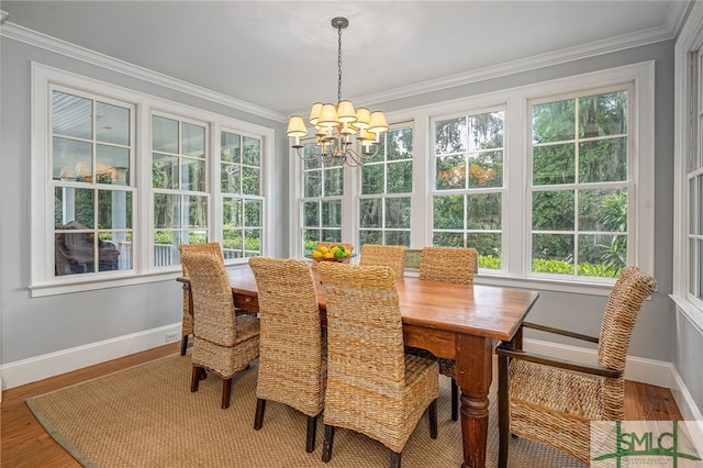 dining room with a notable chandelier, ornamental molding, and hardwood / wood-style floors