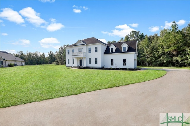 view of front facade featuring a balcony and a front lawn