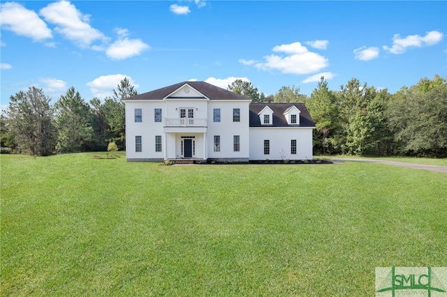 view of front facade featuring a balcony and a front lawn