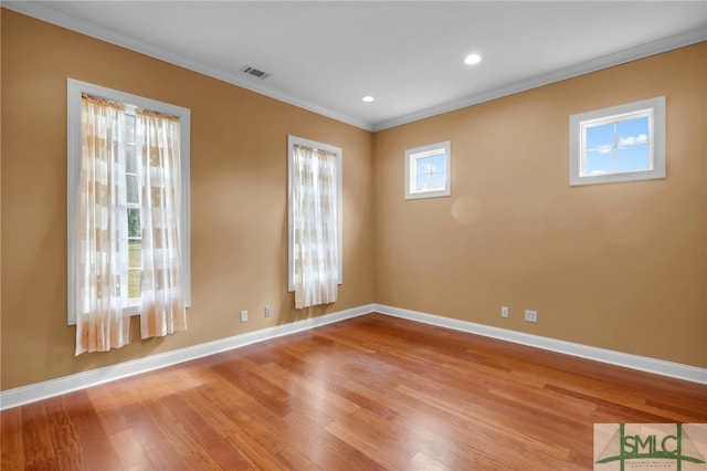 empty room with light hardwood / wood-style flooring and crown molding