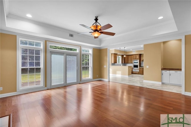 173 Trail Rd S, Midway, GA 31320 - unfurnished living room with visible vents, crown molding, light wood-style flooring, and a raised ceiling