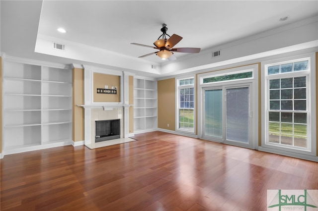 unfurnished living room with ceiling fan, ornamental molding, a raised ceiling, and hardwood / wood-style floors