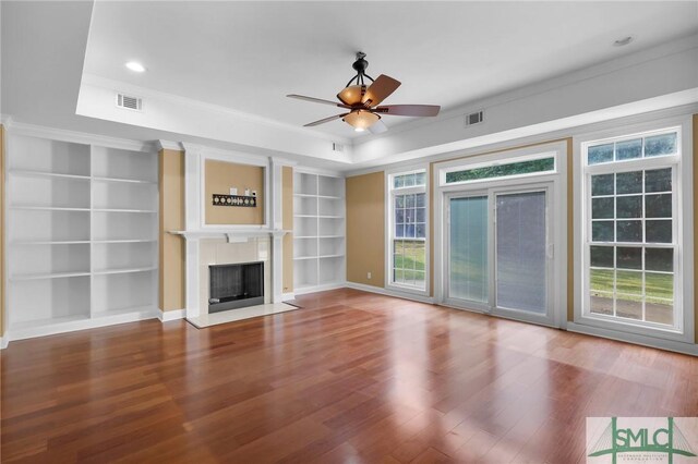 173 Trail Rd S, Midway, GA 31320 - unfurnished living room with ceiling fan, a tray ceiling, a fireplace with flush hearth, visible vents, and wood finished floors