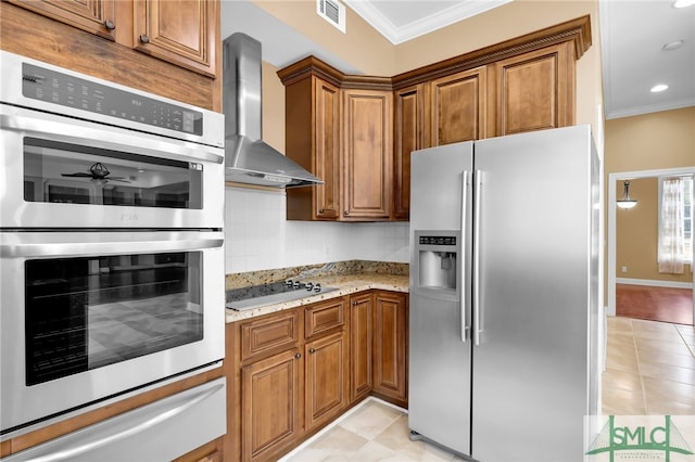 kitchen with appliances with stainless steel finishes, ornamental molding, wall chimney range hood, and light stone counters