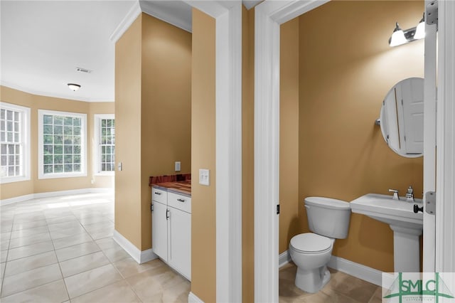 bathroom featuring tile patterned flooring, crown molding, and toilet