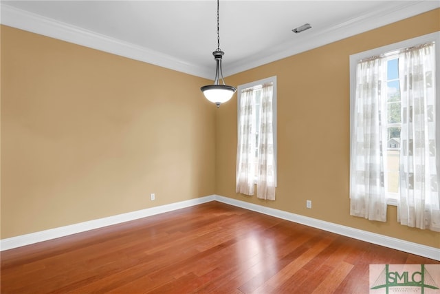 empty room with crown molding and hardwood / wood-style floors