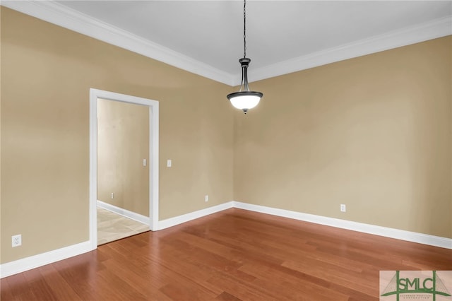 empty room featuring crown molding and hardwood / wood-style floors