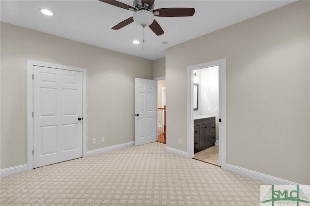 unfurnished bedroom with ensuite bath, light carpet, and ceiling fan