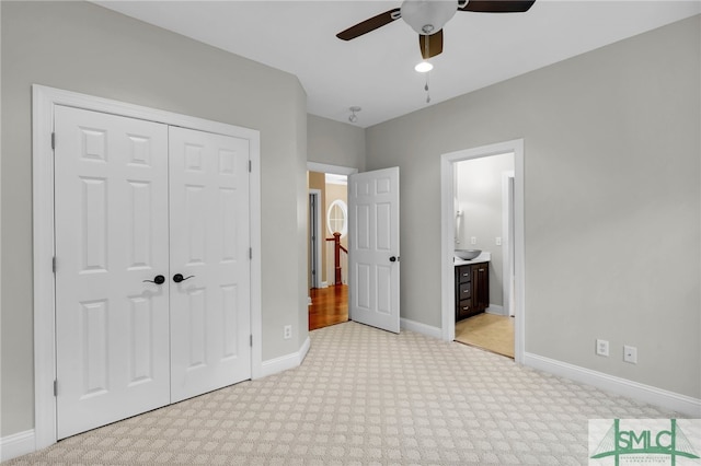 unfurnished bedroom featuring a closet, ceiling fan, light colored carpet, and ensuite bathroom